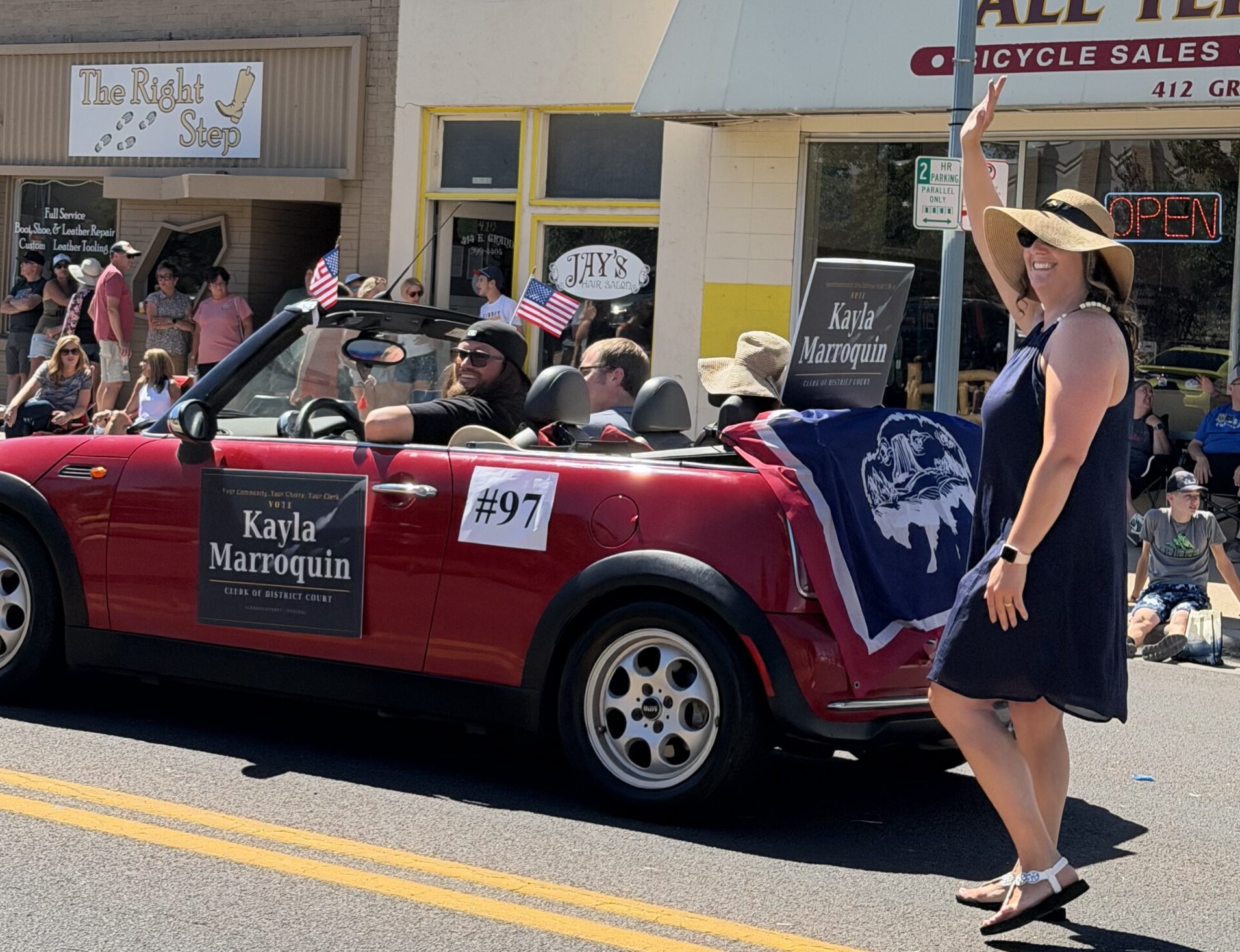 Kayla Marroquin waving beside the campaign car during a community parade